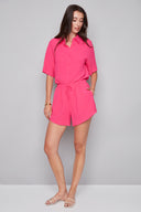 Model wearing the Nora Air Flow Lounge Short in Raspberry, featuring a relaxed fit, tie-front waistband, and asymmetrical hem, front view.