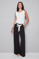 Model wearing the Fiona Vegan Silk Belted Wide Leg Pant in Black, featuring a pleated waist, contrast tie sash belt, and relaxed wide-leg silhouette, front view.