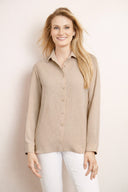 Model wearing the Camillia Air Flow Button-Down Long Sleeve Top in Cashew, featuring a slim fit, long sleeves, and classic button-front design, front view.