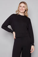 Model wearing the Alessia Provence Sweatshirt in Black, featuring a relaxed fit, crew neckline, and dropped shoulders, front view.