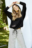 Model wearing Annie Light Ponte Hoodie in Black with drawstring hem and cross-front hood.