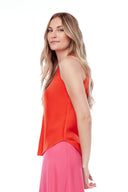 Side view of model wearing the Luna Belize papaya Satin Tank Top, showcasing the fluid satin drape and longer back hem.