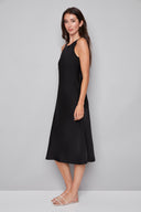 Side view of model wearing the Daphne Belize Satin Sleeveless Dress in Black, showcasing the sleek sleeveless cut and soft satin drape.
