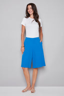 Model wearing the Avery Vegan Silk Bermuda Short in Breeze, featuring a mid-rise pull-on waistband, angled side pockets, and a sleek Bermuda-length silhouette, front view.