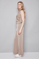 Side view of model wearing the Fiona Belize Satin Wide Leg Pant in Almond with a flowing full-length silhouette and satin finish.