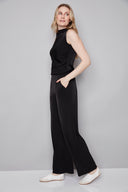 Side view of model wearing the Fiona Belize Satin Wide Leg Pant in Black with a flowing full-length silhouette and satin finish.