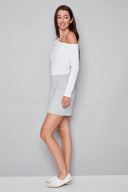 Model wearing the Shira Grey Striped Techno Skort in Grey Stripe, featuring an asymmetric front flap and tailored striped design, side view.