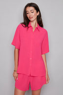 Model wearing the Presley Air Flow Button-Down Top in Raspberry, featuring a slim fit, short sleeves, and classic button-front design, front view.