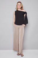 Model wearing the Angel Vegan Silk Tie-Shoulder Top in Black, featuring an asymmetric neckline and statement shoulder tie detail, front view.