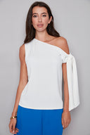 Model wearing the Angel Vegan Silk Tie-Shoulder Top in Cream, featuring an asymmetric neckline and statement shoulder tie detail, front view.