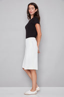Side view of model wearing the Avery Vegan cream Silk Bermuda Short, showcasing the tailored fit and below-the-knee length.