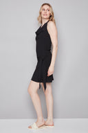 Side view of model wearing the Poppy Air Flow Tie-Front Skirt in Black with an easy slip-on fit and playful summer silhouette.