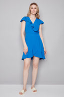 Model wearing the Jessie Vegan Silk Ruffle Dress in Breeze, featuring a flowy silhouette, wrap-inspired neckline, and flounced ruffle details, front view.