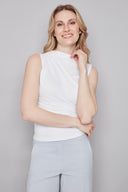 Model wearing the Veronica cloud Provence Top in White, featuring a high neckline and sleek sleeveless silhouette, front view.