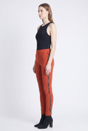 Model wearing the Peyton Burnt Orange Twill Pant with animal side tape detail, side view